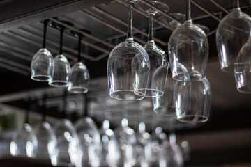Stemware hanging from ceiling rack for elegant display in bar