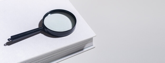Office document magnification, magnifying glass on paper. Business concept with lens and book