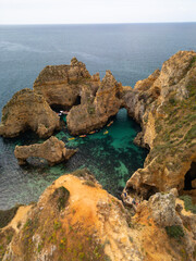 Naklejka premium Photo of Ponta da Piedade from the top of the cliff in a dangerous place with clear water and kayaks
