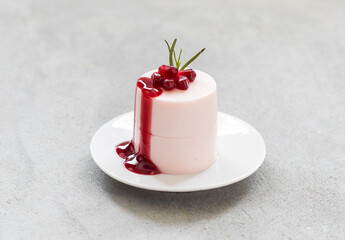 Vegan dessert. Pomegranate cream pudding, Panna Cotta cylindrical shape, with Pomegranate sauce. Close up