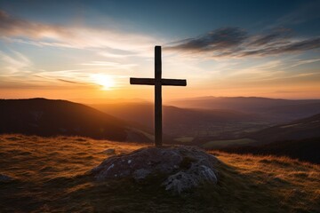 Silhouette of a cross on a hilltop at sunset