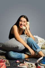 portrait of a happy teenager phoning in a messy room