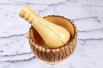 A wooden mortar and pestle on a marble table