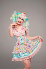 Pretty female clown model in colorful outfit and hair