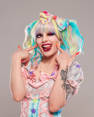 Portrait of pretty female clown in colorful outfit and hair