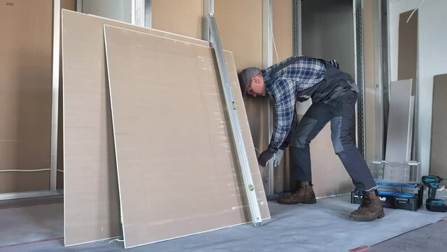 Construction Contractor Working on Wall in Room