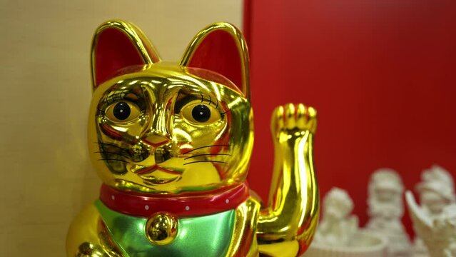 Maneki Neko, Japanese Lucky Cat. Golden cat brings good luck and wealth closeup