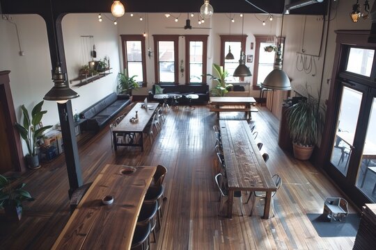 A large room with a wooden table and benches for communal coworking, A communal coworking space with long communal desks, shared amenities, and a laid-back, collaborative atmosphere