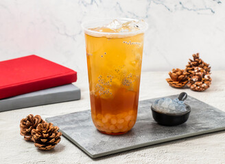 Han Tian Ai Jade Little Perilla iced tea served in disposable glass isolated on board side view of...