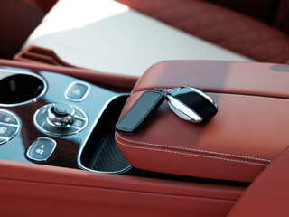 Car ignition key at the armrest. Rental car keys in the rays of sun at expensive suv car rental service close up