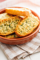 Garlic crisp bread Slices Topped With Herbs in bowl.