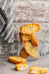 Garlic crisp bread Slices Topped With Herbs in jar on kitchen table.