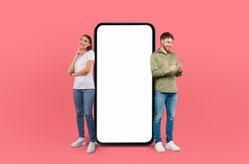 A man and a woman are depicted standing next to a large phone in this scene. They appear to be looking at the phone, possibly engaged in a conversation or using its features