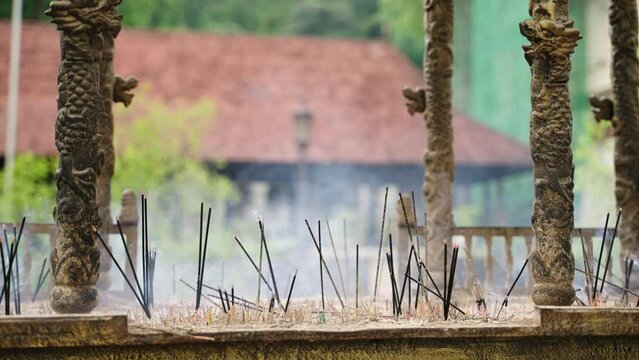 Incense burn ancient temple, releasing smoke amongst intricately carved pillars. Calm ambiance in Kandy, worship, tradition. Ritual practice brings serenity, timeless devotion sacred site. Slowmo