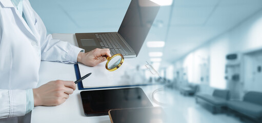 Doctor looking through a magnifying glass at documents.