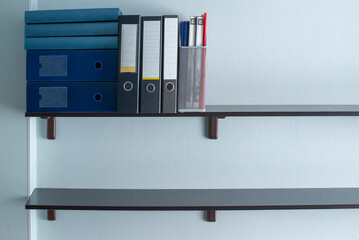 bookshelves on a light wall with folders for papers and documents