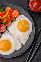 Delicious nutritious breakfast with fried eggs, sausage, steamed vegetables
