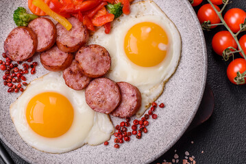 Delicious nutritious breakfast with fried eggs, sausage, steamed vegetables