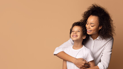 African American woman is shown holding a child in her arms, bond between the two as she securely cradles the child, panorama with copy space - Powered by Adobe