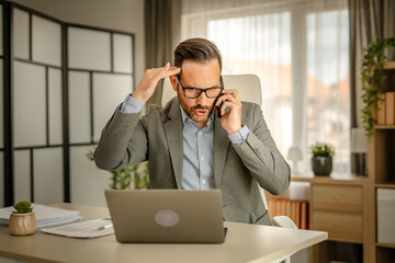 One men working in the office using technology talking on mobile phone