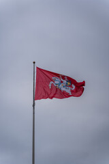 Historical Lithuanian flag, coat of arms of Lithuania, consisting of an armour-clad knight on horseback holding a sword and shield, is also known as Vytis, waving in the wind against cloudy sky