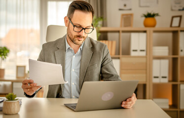 One men working in the office using technology and holding papers