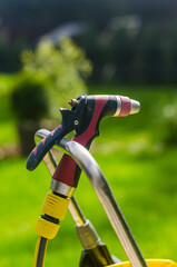 On a sunny day, the water hose is held onto the water pipe.