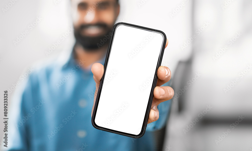 Poster unrecognizable man holding a modern cell phone device in his hand, looking at the screen. the backgr