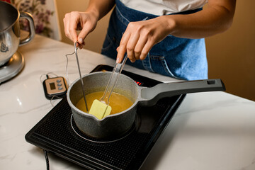 Hot stove and chef's in hands takes butter for the cream