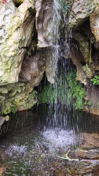 Vertical cave waterfall slowed down. A vertical cave waterfall cascades in slow motion, the water gracefully tumbling down into the depths below.