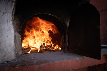 Fire and burn coals in stone oven. Oven made of bricks and clay.
