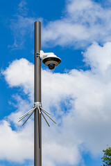 Security camera on a light pole on the street.Security camera and urban video in front of blue sky....