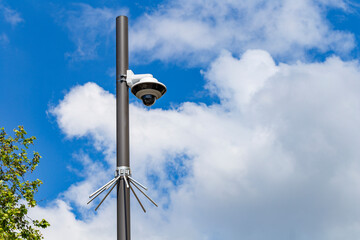 Security camera on a light pole on the street.Security camera and urban video in front of blue sky. Outdoor cctv video surveillance cameras. Safety system area control outdoor with copy space.