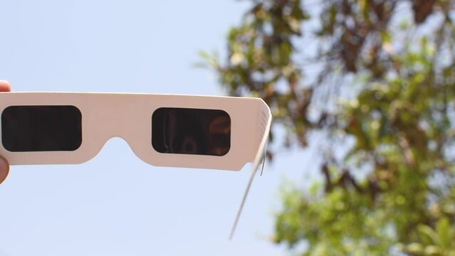 Lentes para ver un eclipse solar apuntando al cielo 