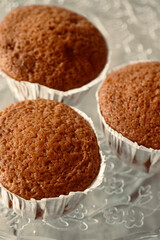 Close up of freshly baked cupcakes on top of glass tray.