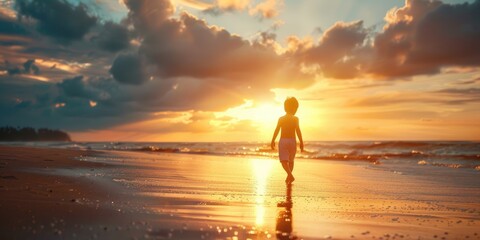 Little boy walking on the beach at sunset AIG51A.