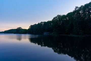 Fototapeta premium Looking onto a calm Wisconsin lake in the evening as the sun goes down.