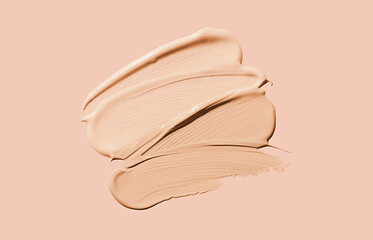 Cosmetic liquid concealer or foundation smudge assortment set palette on nude pink background