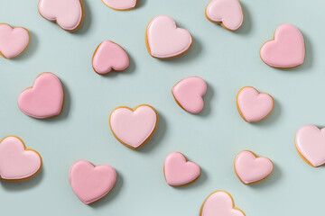 Seamless pattern of heart shaped cookies with pink glaze on blue background. Valentines day...