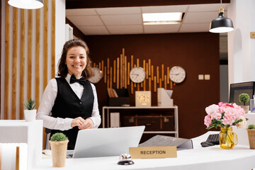 Front desk staff smiling at reception, welcoming hotel guests and providing luxury room services....