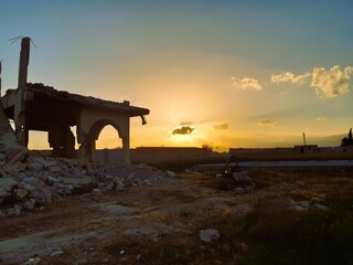 Sunset over the rubble of a house destroyed as a result of the war