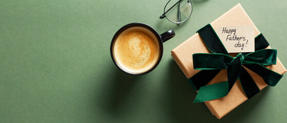 Happy Fathers Day gift box, coffee cup, glasses on dark green background