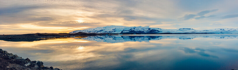 Icelandic panorama of frozen icy lake near snowy mountain tops, panoramic view of scandinavian...