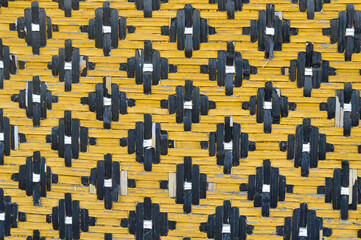 A full-frame capture reveals the intricate weave of a handmade Malay traditional mat, crafted from bamboo.