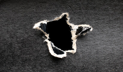 torn hole in black cardboard