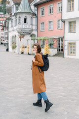 Woman turning to smile while exploring a city