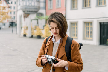 Woman using an analog camera while visiting a city