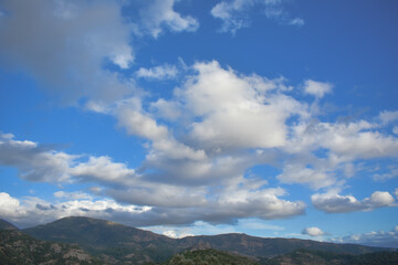 Obraz premium Green mountain scene with white clouds and blue sky 