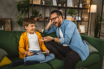 Father with eyeglasses and son use tablet for homework browse internet