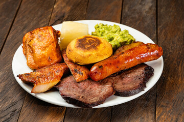 Typical fritanga with beef, chicken, beef, chorizo, yuca and arepa - Traditional Colombian gastronomy